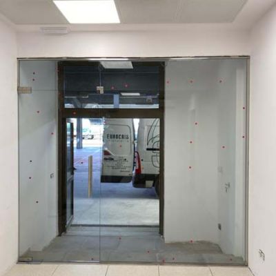 Vista desde el interior de la colocación de una  puertas de vidrio abatible